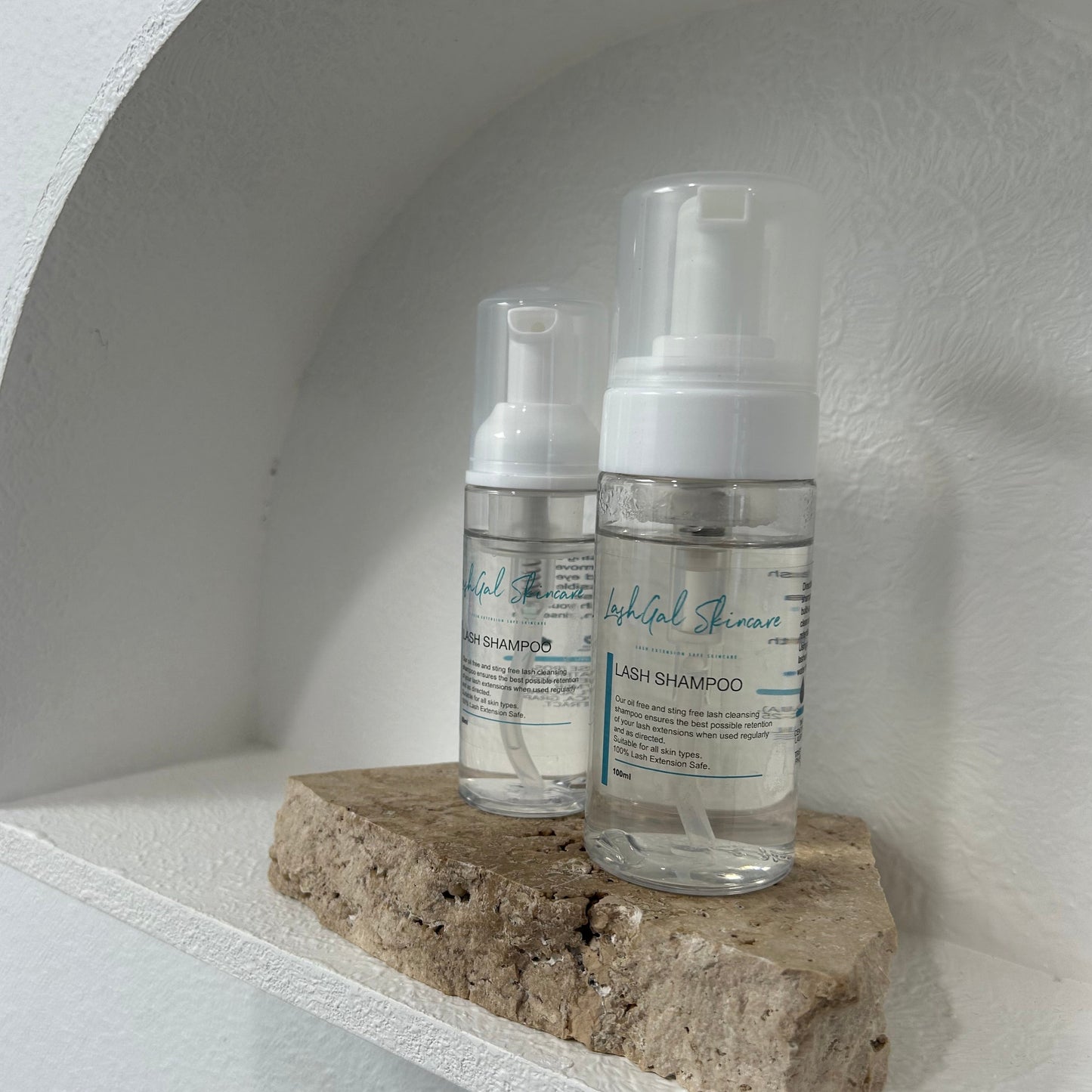 Two bottles of Lash Shampoo placed on a shelf, against a white background.